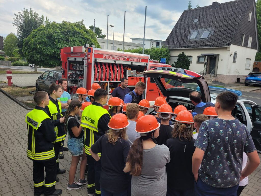 Besonders spannend war natürlich die Vorstellung des Polizeiautos. Die Jugendlichen durften das Fahrzeug von innen und außen erkunden und erfuhren, welche Ausrüstung und Technik darin zum Einsatz kommt. Die Polizeibeamten erklärten, wie sie das Auto im Dienst nutzen und wie es ihnen hilft, ihre Aufgaben effektiv zu erfüllen.
Die Begegnung zwischen der Jugendfeuerwehr und der Polizei war für beide Seiten eine bereichernde Erfahrung. Die Jugendlichen konnten einen Einblick in die Arbeit der Polizei gewinnen und die Polizeibeamten hatten die Möglichkeit, den jungen Menschen ihre Arbeit näherzubringen und möglicherweise das Interesse an einer Karriere im Sicherheitsbereich zu wecken.
Solche Begegnungen zwischen verschiedenen Sicherheitsorganisationen sind von großer Bedeutung und wir bedanken uns für die spannenden Einblicke bei Markus und Lukas von der Polizei in Montabaur.